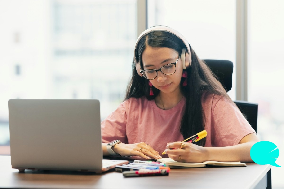 Estudiante con auriculares en una clase de inglés online frente al portátil