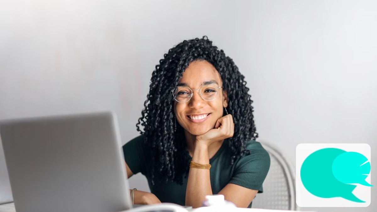 Persona sonriente en una clase de inglés online frente al portátil practicando la pronunciación