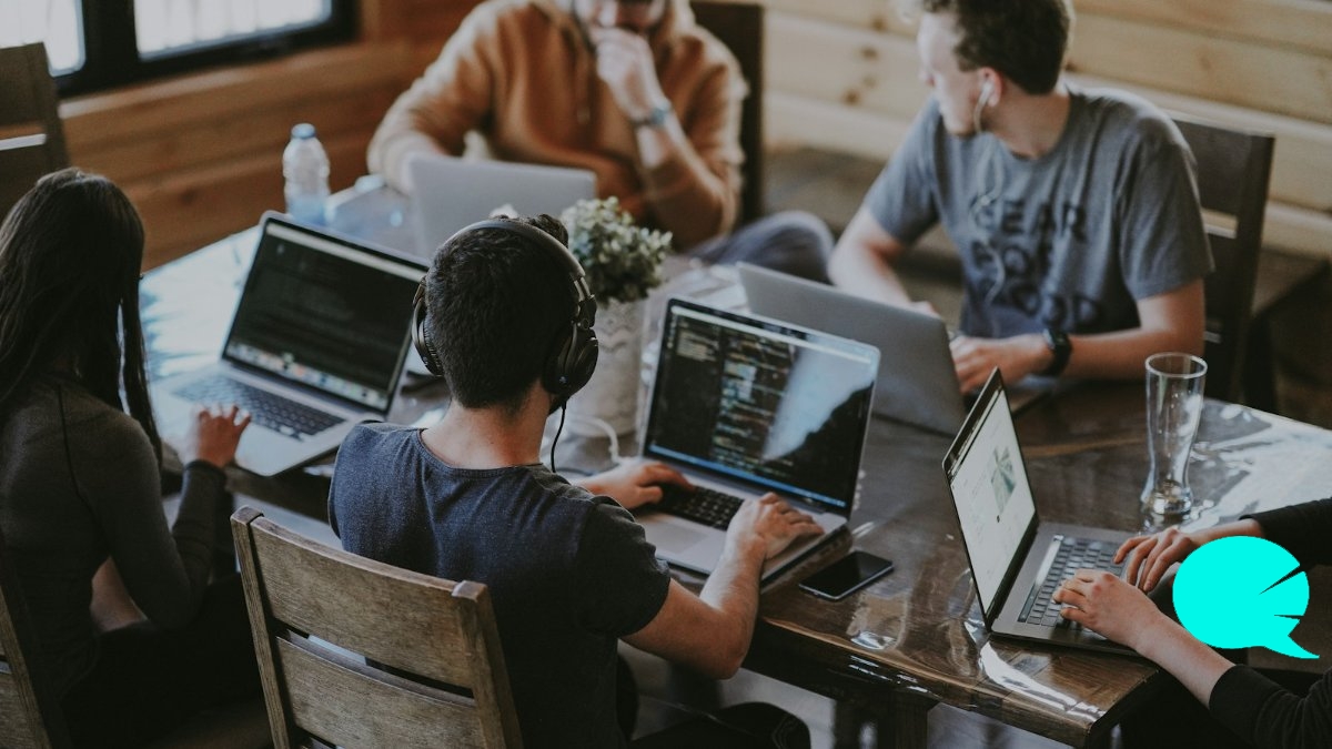 Equipo de profesionales colaborando con portátiles en una oficina
