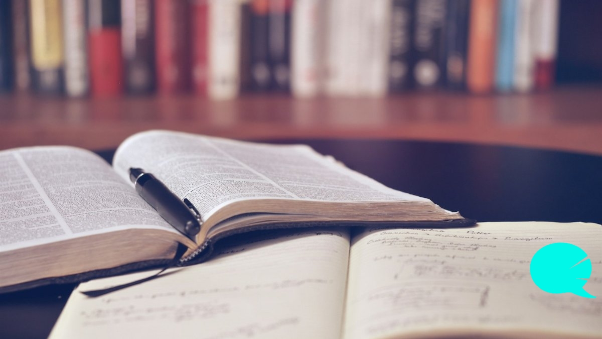 Persona escribiendo vocabulario de inglés en un cuaderno de notas